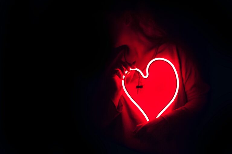 Image pour article de blog. Image noir avec une personne tenant un coeur d'amour lumineux rouge vers son coeur - Serenity Body Mind