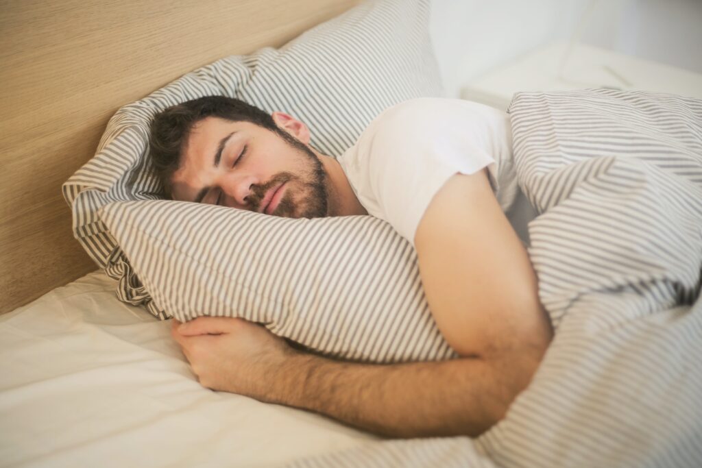 Image d'un homme qui dort dans son lit de manière confortable pour un article de blog Serenity Body Mind #SBM #bien-être #sommeilreparateur