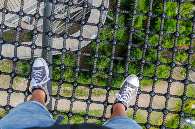 Image article de blog homme vu vers pieds en exterieurs sur une hauteur à plusieurs mètres de distance de la Terre. #SerenityBodyMind #SBM
