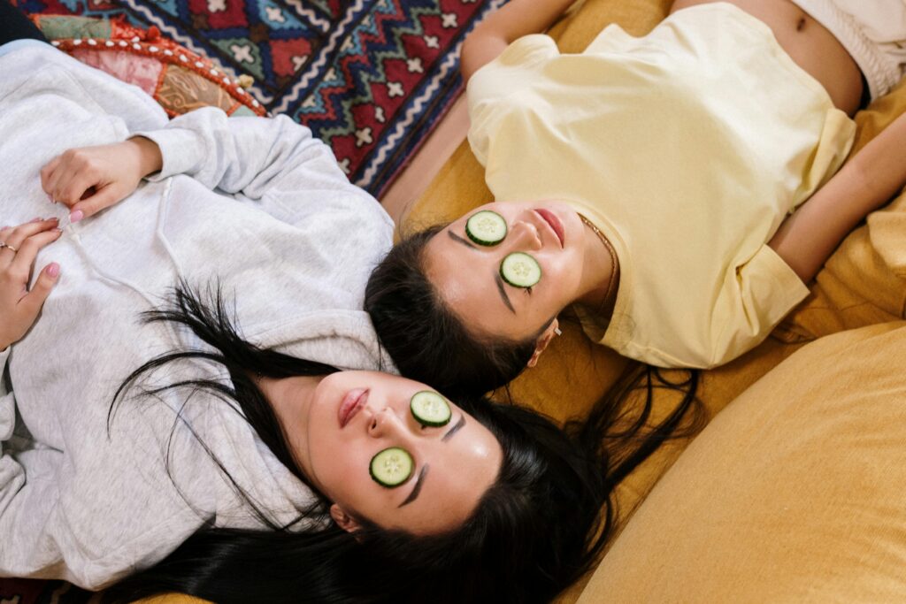 Image deux personnes allongées se relaxant avec tranches de concombre sur les yeux